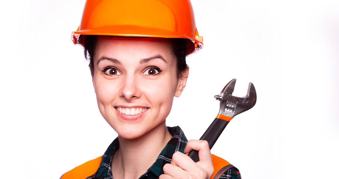 Femme avec casque et clé à molette