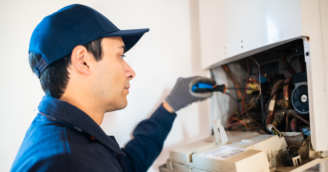 Technicien réparant un chauffe eau.