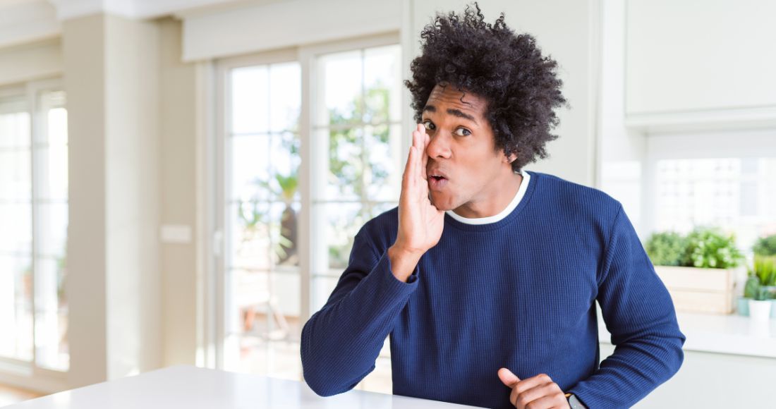 Jeune homme avec une main vers la bouche